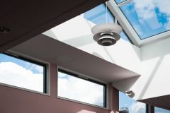 Low angle shot of a lamp hanging inside a building with a glass ceiling