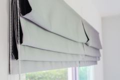 Szare rolety zwinięte w oknie